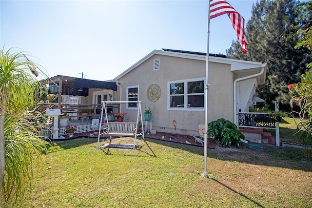 2132 40th Ave N, Saint Petersburg, FL 33714 - view of front facade featuring a front yard, stucco siding, and a deck