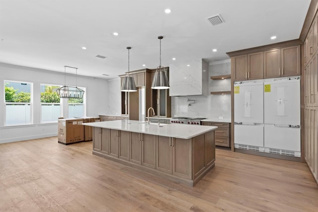 3406 W Alline Ave, Tampa, FL 33611 - kitchen with an island with sink, light wood-type flooring, light countertops, recessed lighting, and a sink