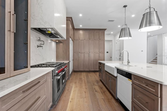 3406 W Alline Ave, Tampa, FL 33611 - kitchen with range with two ovens, extractor fan, a sink, dishwasher, and light wood-style floors
