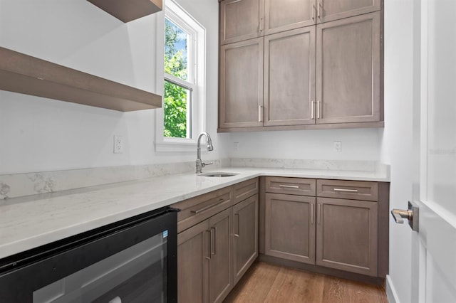3406 W Alline Ave, Tampa, FL 33611 - kitchen featuring beverage cooler, a sink, light wood-style floors, open shelves, and light stone countertops