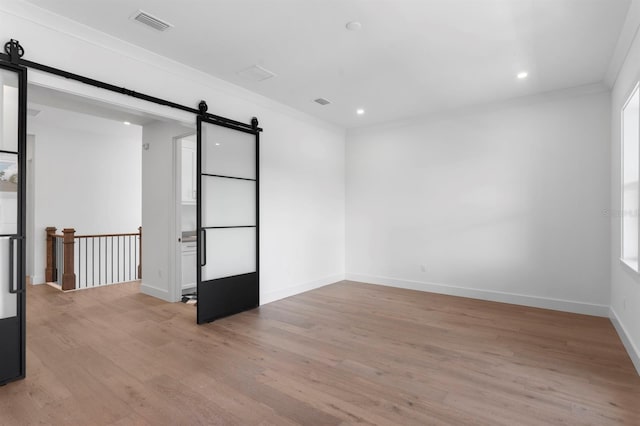 3406 W Alline Ave, Tampa, FL 33611 - spare room with a barn door, light wood-style floors, crown molding, and recessed lighting
