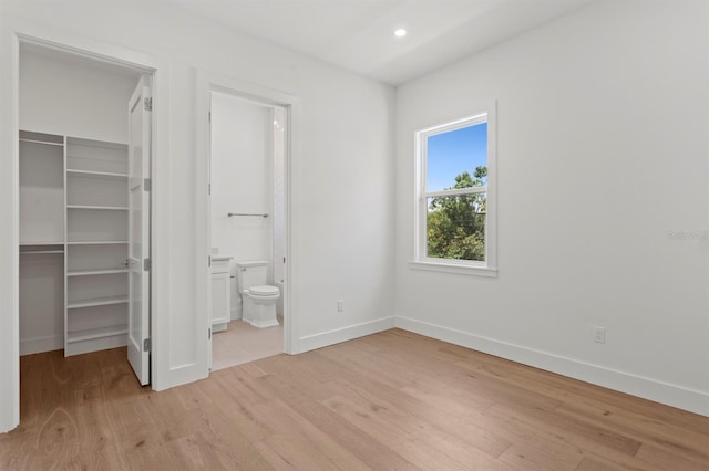 3406 W Alline Ave, Tampa, FL 33611 - unfurnished bedroom with a walk in closet, baseboards, light wood-style floors, and recessed lighting