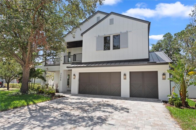 3406 W Alline Ave, Tampa, FL 33611 - modern farmhouse with a garage, a standing seam roof, decorative driveway, a balcony, and brick siding