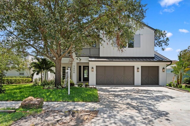 3406 W Alline Ave, Tampa, FL 33611 - modern farmhouse featuring a standing seam roof, concrete driveway, a garage, a balcony, and metal roof