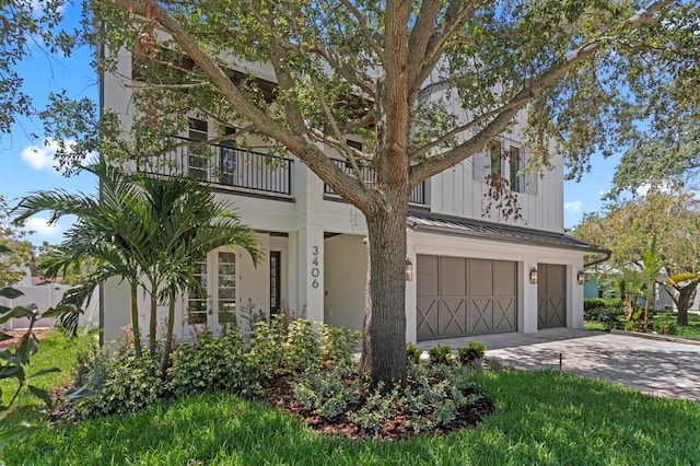 3406 W Alline Ave, Tampa, FL 33611 - view of front of property featuring a balcony, a garage, concrete driveway, a standing seam roof, and metal roof