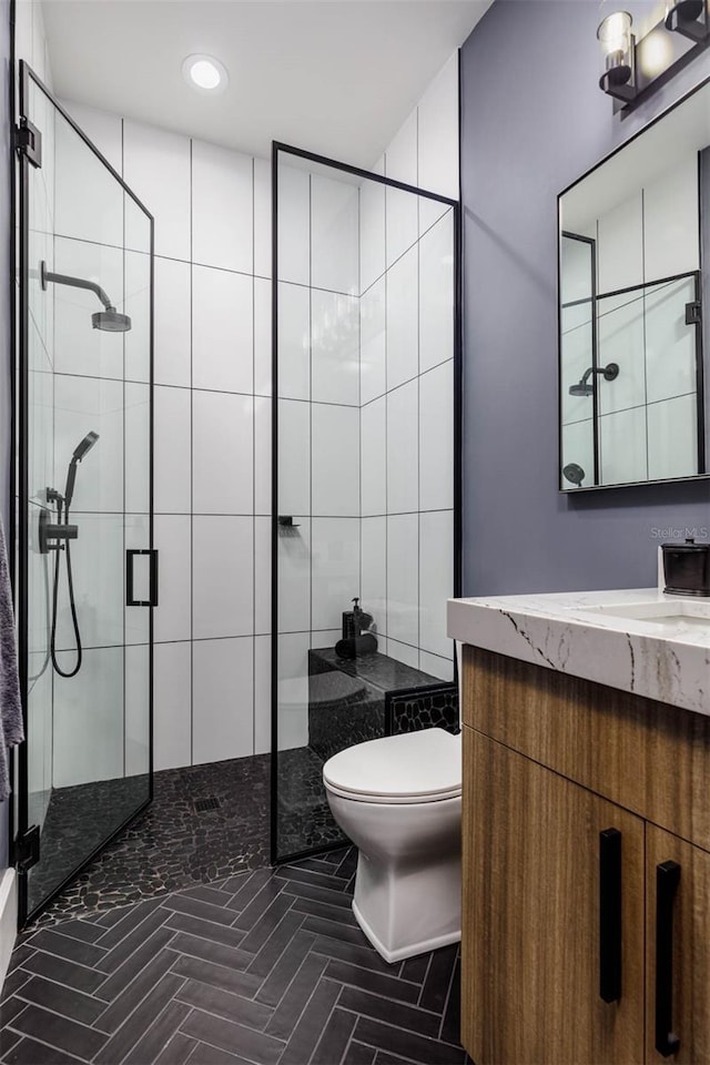 bathroom with vanity, toilet, recessed lighting, and a stall shower