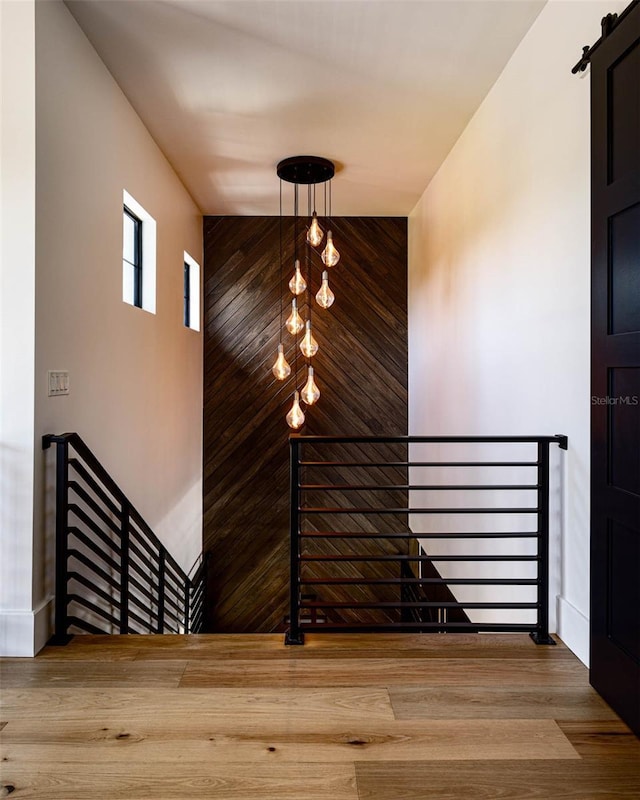 stairway featuring a barn door and wood finished floors