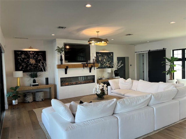 living area with visible vents, a barn door, and recessed lighting