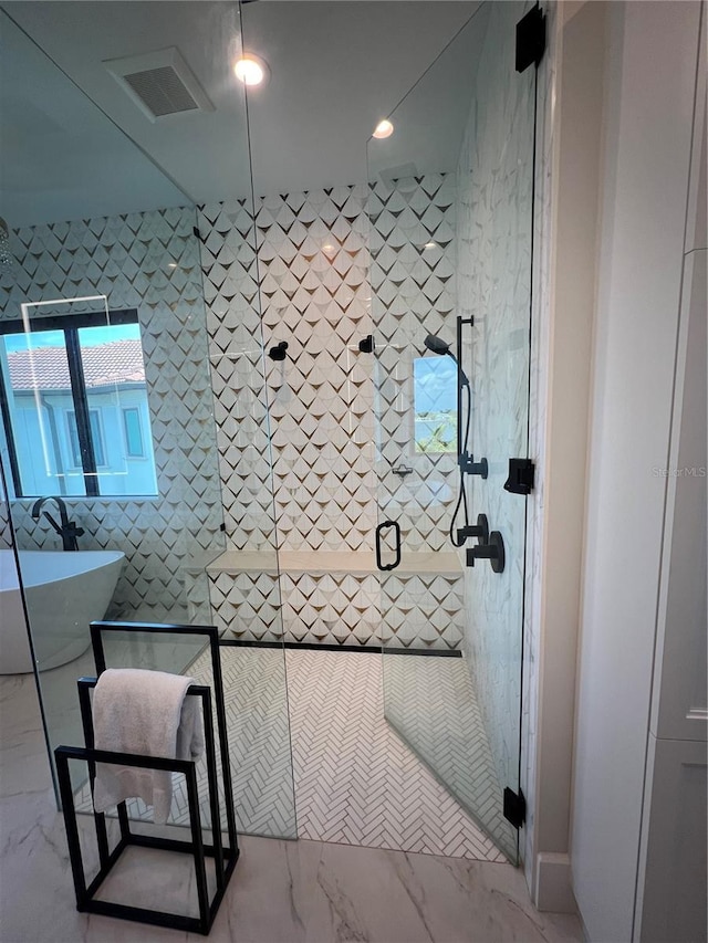 full bathroom with a shower stall, marble finish floor, tile walls, a sink, and visible vents