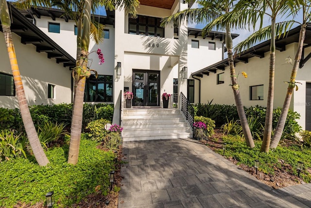 view of exterior entry with stucco siding and french doors