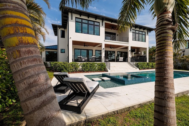 rear view of house featuring a patio, ceiling fan, stucco siding, and a balcony