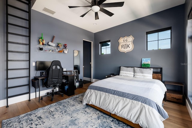 bedroom featuring baseboards, visible vents, and wood finished floors