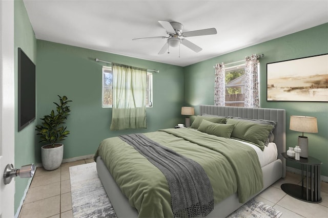 bedroom with a ceiling fan, light tile patterned flooring, and multiple windows