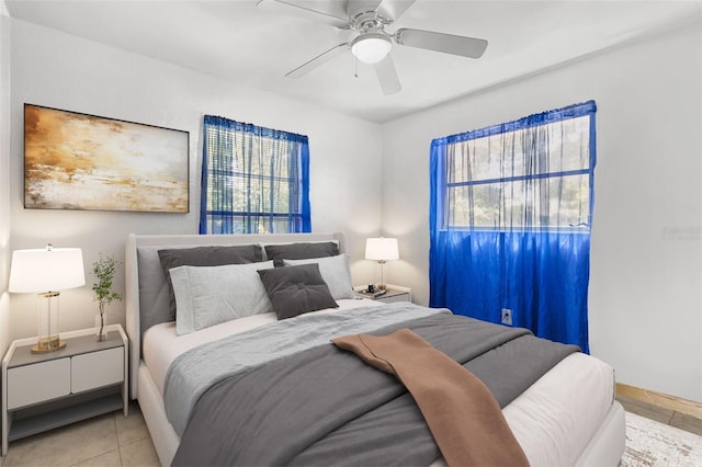 tiled bedroom featuring ceiling fan and baseboards