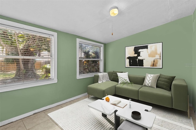 tiled living room featuring baseboards and vaulted ceiling