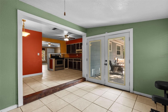 interior space featuring electric range, french doors, light tile patterned floors, and visible vents