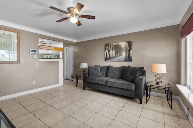 living room with baseboards, a ceiling fan, and light tile patterned flooring