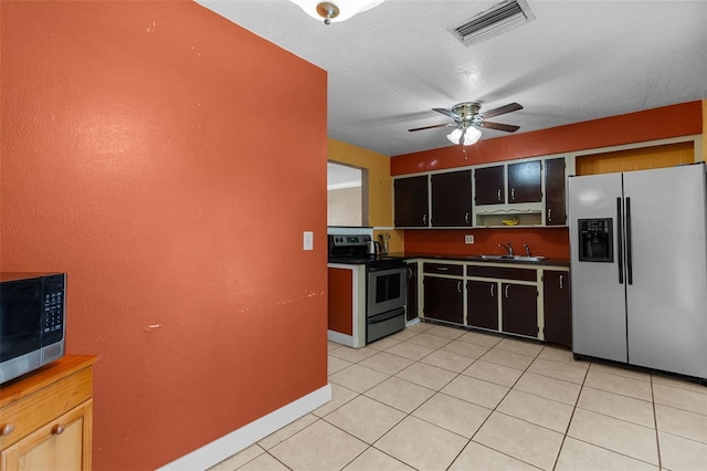 kitchen featuring light tile patterned floors, a ceiling fan, visible vents, appliances with stainless steel finishes, and a sink