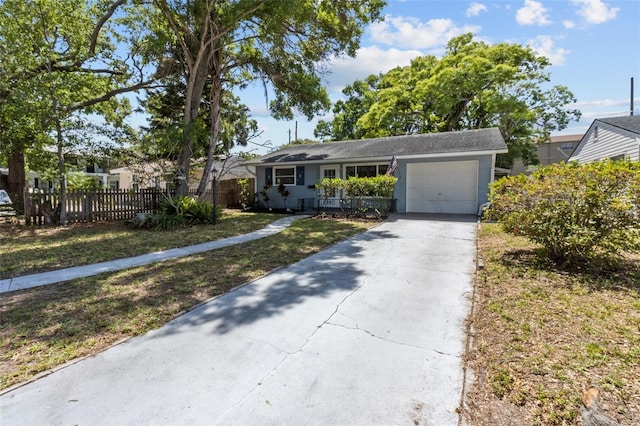 ranch-style home with concrete driveway, a front yard, fence, and a garage