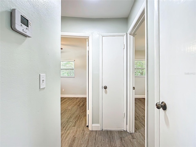 hallway with baseboards and wood finished floors