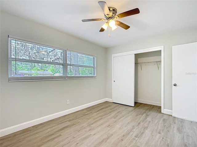 unfurnished bedroom featuring baseboards, ceiling fan, a closet, and light wood finished floors
