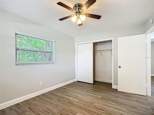 unfurnished bedroom featuring a ceiling fan, a closet, baseboards, and wood finished floors