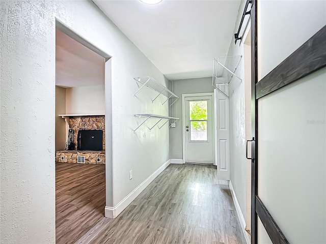 corridor featuring baseboards and wood finished floors