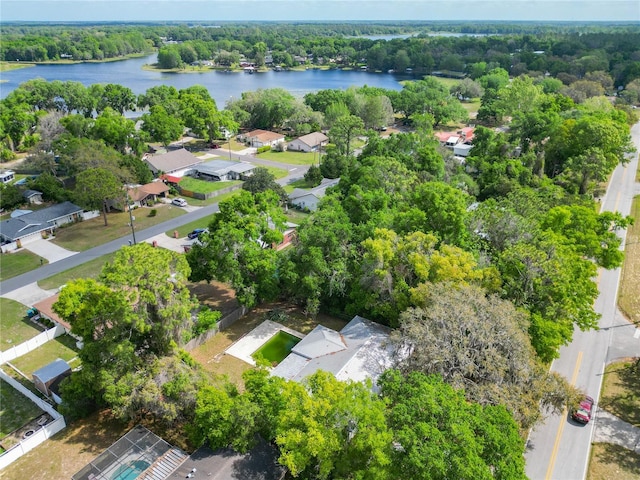 drone / aerial view with a water view, a view of trees, and a residential view