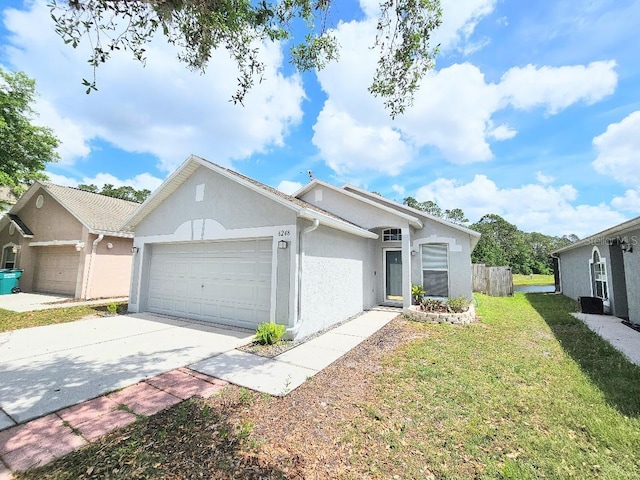 view of front facade with fence, driveway, a garage, stucco siding, and a front lawn