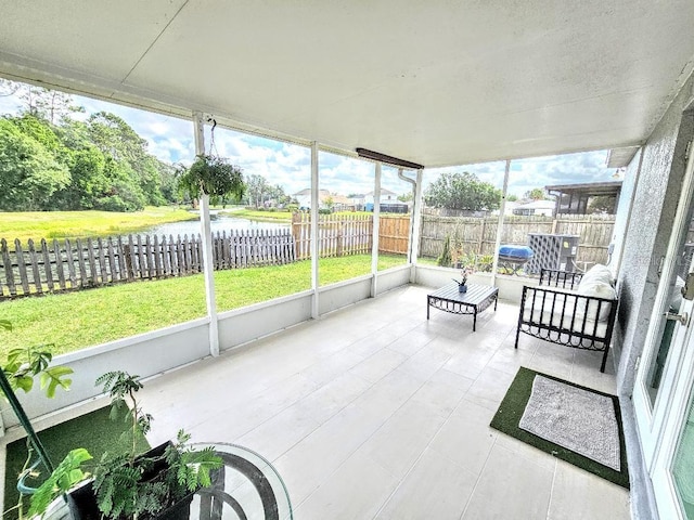 unfurnished sunroom featuring a water view
