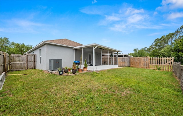 back of house featuring stucco siding, a fenced backyard, cooling unit, a lawn, and a sunroom