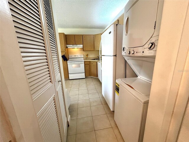 1423 Pine Glen Ln Unit D2, Tarpon Springs, FL 34688 - laundry room featuring estacked washer and dryer, light tile patterned floors, and a textured ceiling