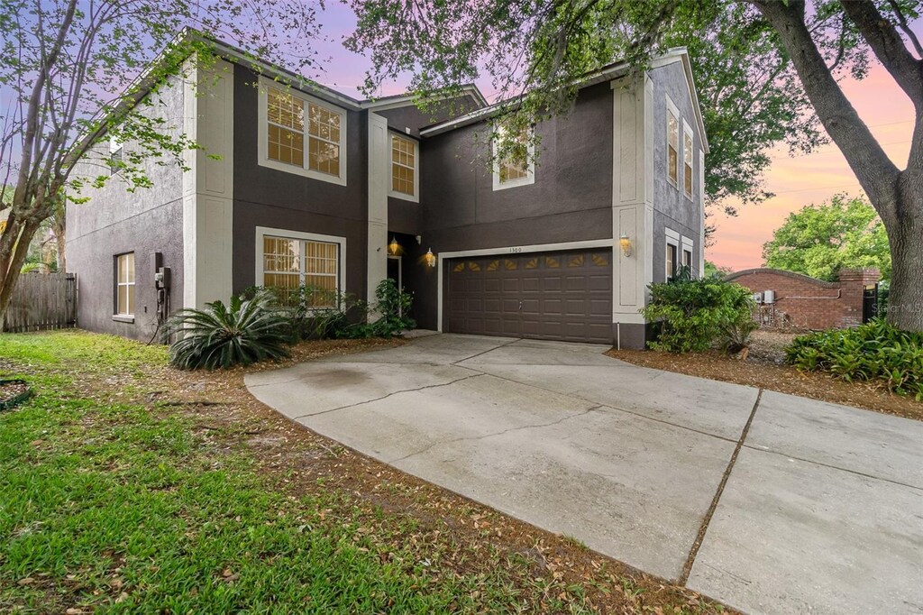 1300 Holly Glen Run, Apopka, FL 32703 - view of front of home with driveway, fence, a garage, and stucco siding