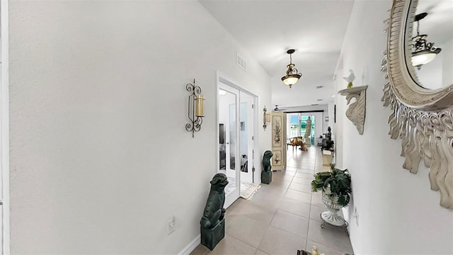 hall with light tile patterned flooring, baseboards, visible vents, and french doors