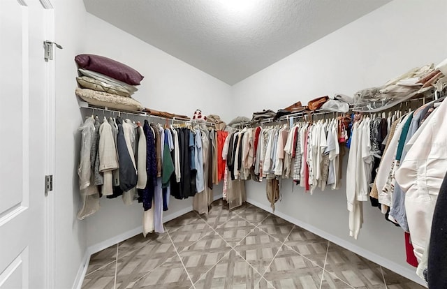 walk in closet with lofted ceiling