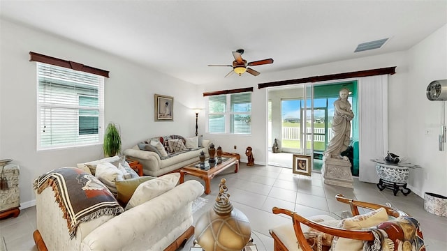 living area with light tile patterned flooring, baseboards, visible vents, and ceiling fan