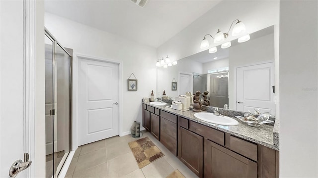bathroom with tile patterned floors, a sink, double vanity, and a shower stall
