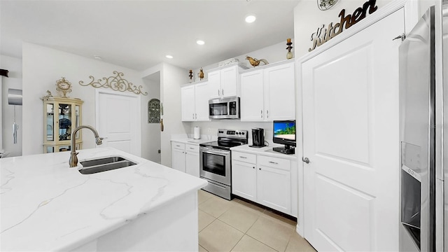 kitchen featuring white cabinetry, light tile patterned floors, a sink, and stainless steel appliances