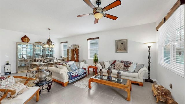 living area featuring tile patterned flooring, baseboards, and ceiling fan