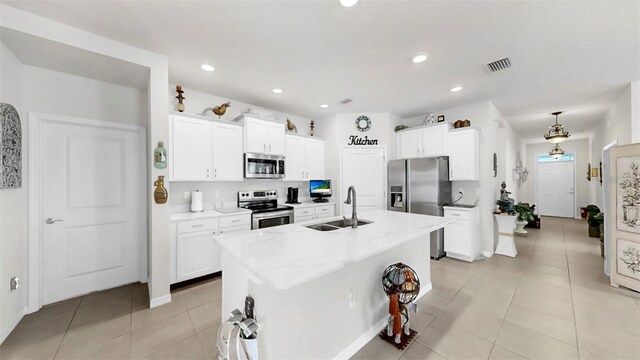 kitchen with stainless steel appliances, a sink, light tile patterned flooring, visible vents, and white cabinets