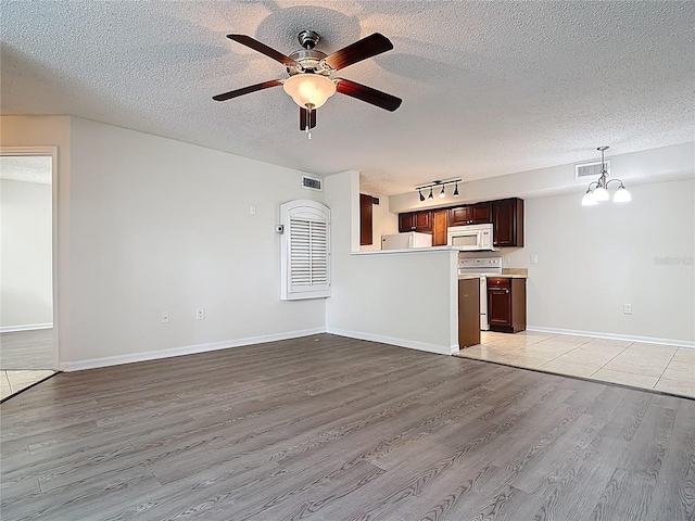 unfurnished living room with visible vents, light wood-style flooring, ceiling fan, and a textured ceiling