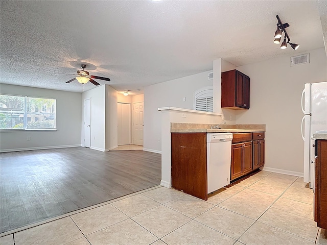 kitchen featuring white appliances, visible vents, a ceiling fan, and a textured ceiling