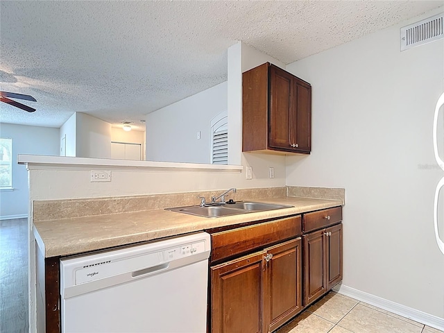 kitchen with a textured ceiling, a sink, visible vents, a ceiling fan, and white dishwasher