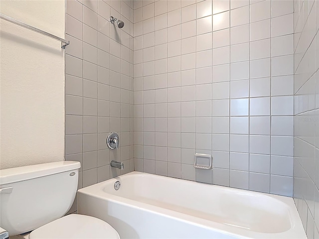 full bathroom featuring a textured wall, toilet, and washtub / shower combination