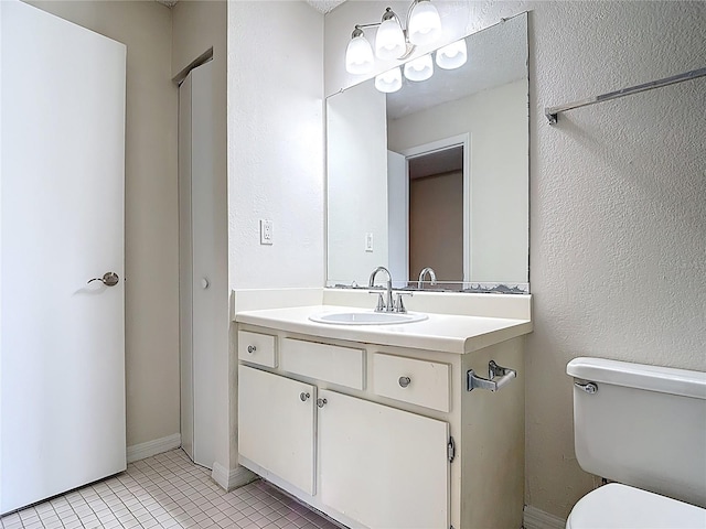 half bathroom featuring tile patterned floors, toilet, and vanity