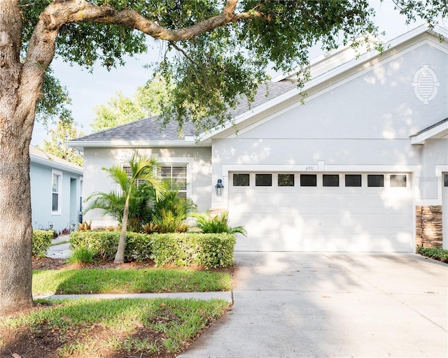 ranch-style home featuring an attached garage, driveway, and stucco siding
