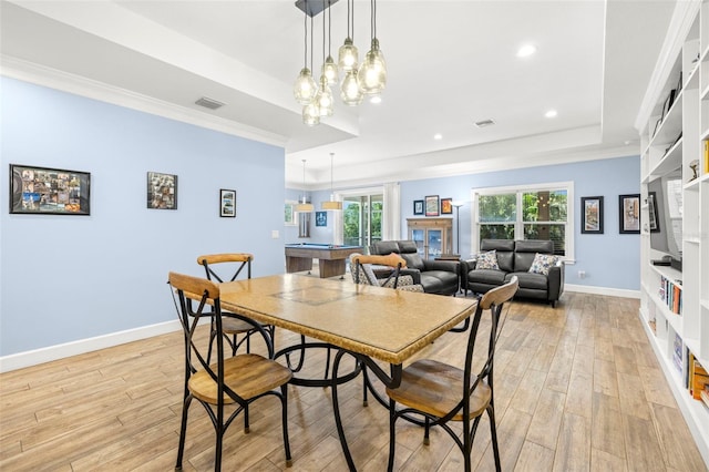 2623 57th St S, Gulfport, FL 33707 - dining space with crown molding, light wood-style flooring, visible vents, a raised ceiling, and baseboards