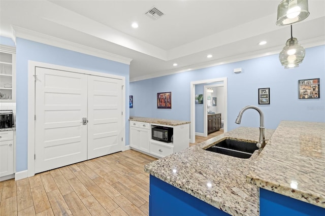2623 57th St S, Gulfport, FL 33707 - kitchen with crown molding, black microwave, light wood-style flooring, visible vents, and a sink