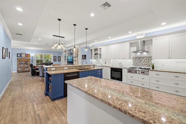 2623 57th St S, Gulfport, FL 33707 - kitchen featuring wall chimney range hood, blue cabinetry, black appliances, a tray ceiling, and a sink