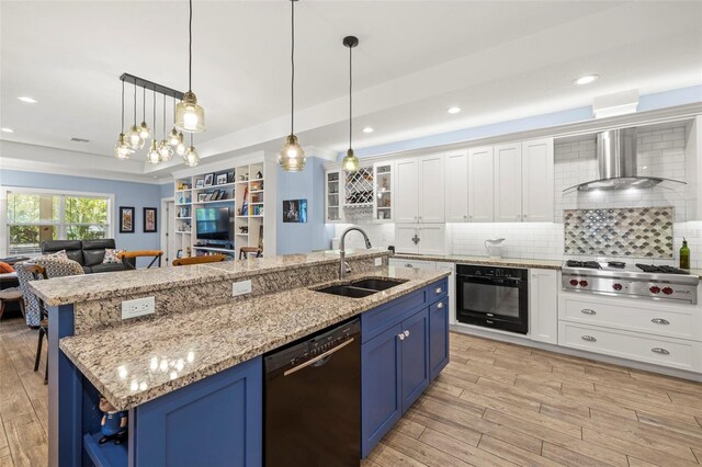 2623 57th St S, Gulfport, FL 33707 - kitchen with blue cabinetry, wall chimney range hood, black appliances, a sink, and open floor plan